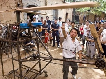 Wu turns the rotor blades of his self-made helicopter in preparation for its maiden flight, in Jiuxian county
